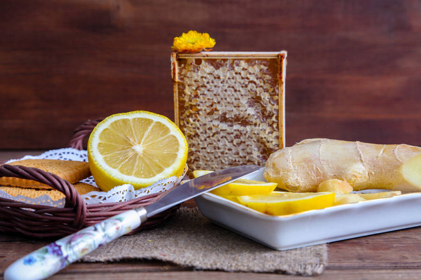 lices of  lemon and ginger  with honeycomb on a wooden background - Foto, Imagen