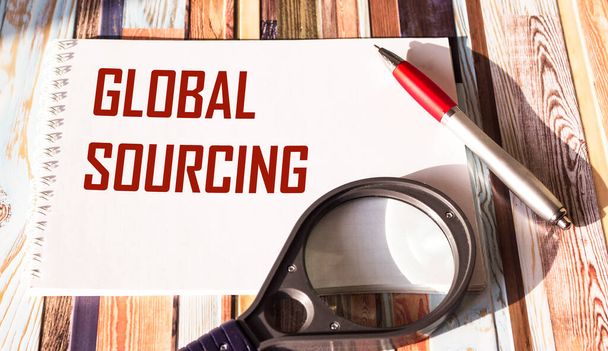El texto de Global Sourcing está escrito en un bloc de notas. Concepto de negocio para la práctica de la búsqueda del mercado global de bienes - Foto, imagen
