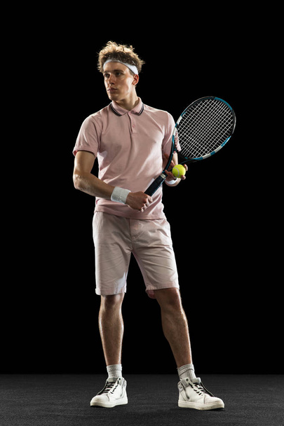 Portrait of young man, professional tennis player isolated on black background. - Fotoğraf, Görsel