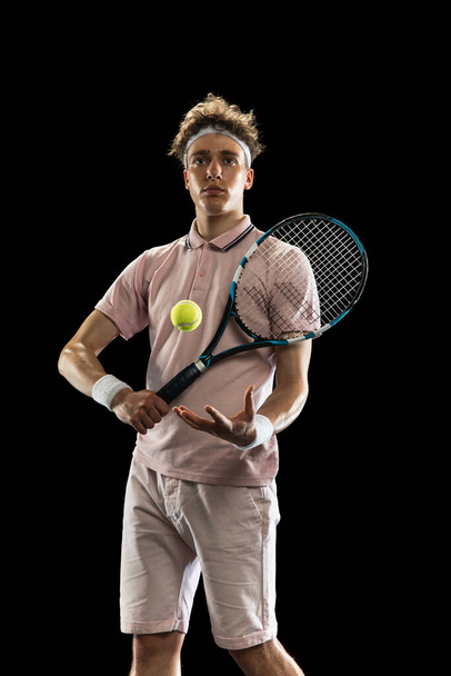 Portrait of young man, professional tennis player isolated on black background. - Foto, immagini