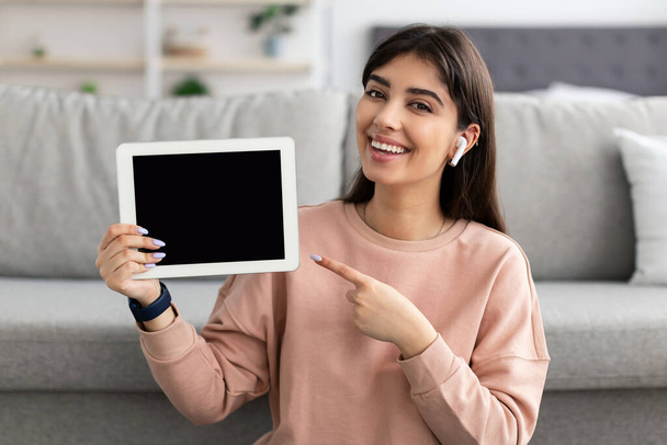 Mujer mostrando pantalla de tableta vacía en blanco para maqueta - Foto, Imagen
