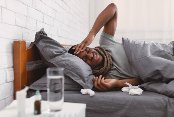 Kranker Kerl mit starken Kopfschmerzen liegt zu Hause im Bett - Foto, Bild
