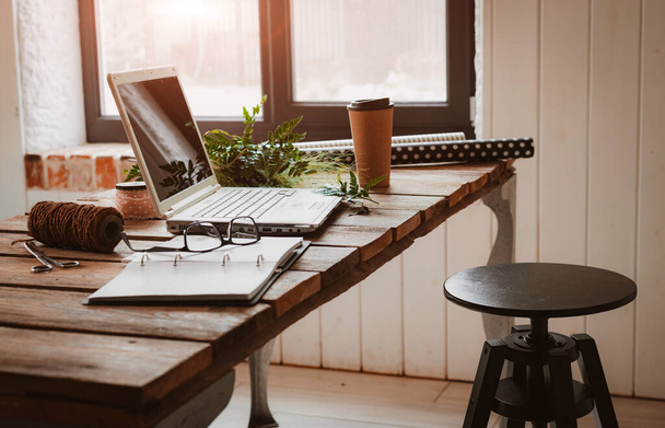 Laptop ist eine Mischung aus Bürobedarf und Gadgets auf dem Hintergrund eines Holztisches. - Foto, Bild