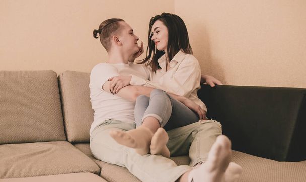 couple at home in home clothes lie on the couch and hug each other - Foto, Bild