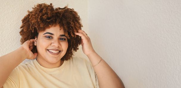 Kaunis iloinen hymyilevä kaareva plus koko Afrikkalainen musta nainen afro hiukset muodostavat poseeraa beige t-paita valkoisella taustalla. Kehon epätäydellisyys, kehon hyväksyntä, kehon positiivinen ja monimuotoisuus - Valokuva, kuva