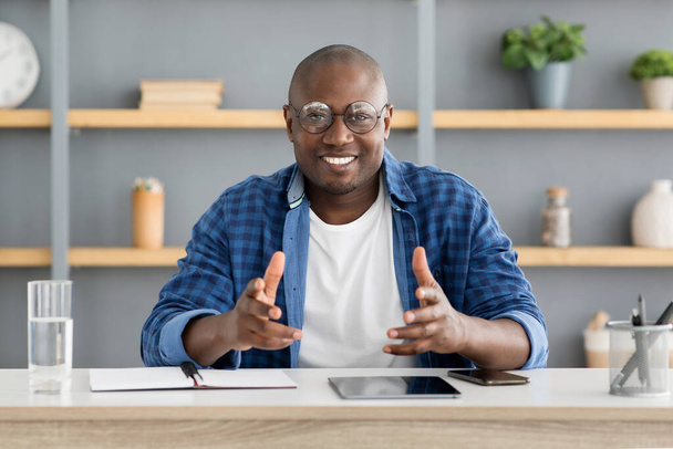 Boldog afro-amerikai üzleti edző beszél és gesztikulál a kamera előtt, otthon dolgozik iroda belsejében - Fotó, kép