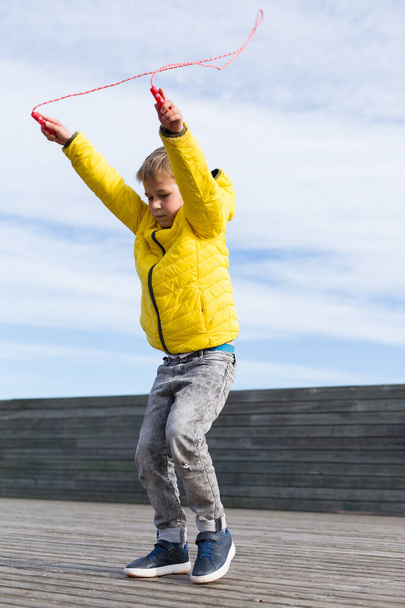 Elegante joven, adolescente está saltando con saltar la cuerda, al aire libre - Foto, Imagen