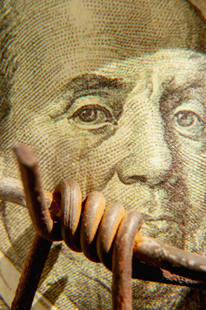 Gazdasági hadviselés, szankciók és embargórombolás. Zárd össze a szögesdrótot az amerikai dollárral. Szelektív fókusz. Függőleges kép. - Fotó, kép