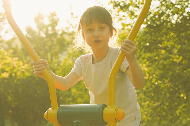 Detailní záběr portrét krásné mladé dívky se zabývá sportem na pouličním simulátoru na slunci. Vodorovný obrázek. - Fotografie, Obrázek