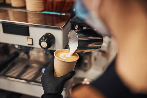 Skillful barista creating a fine pattern on latte surface - Valokuva, kuva
