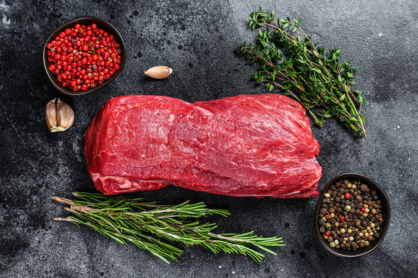 Raw fillet Tenderloin beef meat for steaks with thyme and rosemary. Black background. Top view - Foto, Bild