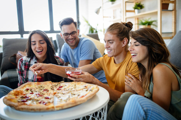 Group of happy friends are having party at home, eating pizza and having fun. - Fotó, kép