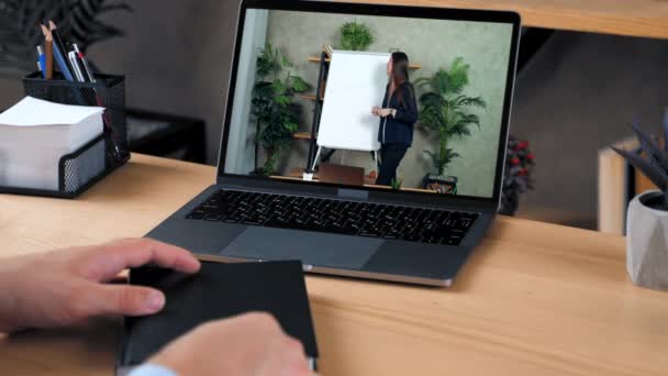 Человек на домашнем офисе изучать онлайн курс ноутбук, пишет в блокноте слушать учителя - Кадры, видео