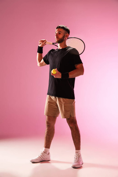 Young caucasian man playing tennis isolated on pink studio background, action and motion concept - Photo, image