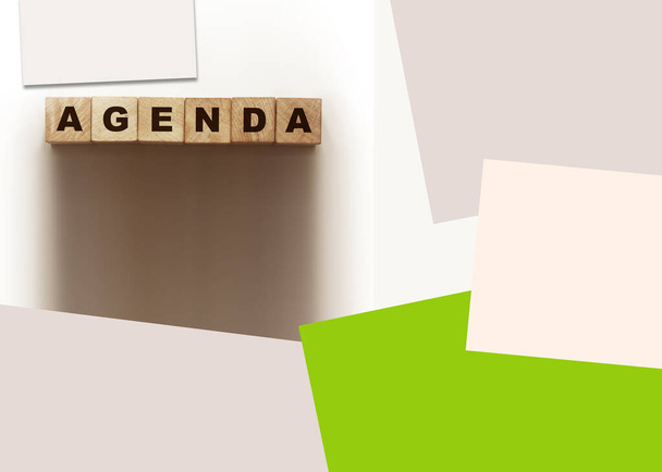 Agenda slovo napsané na dřevěné bloky na bílém a barevném papíru kolem. Obchodní koncept. - Fotografie, Obrázek