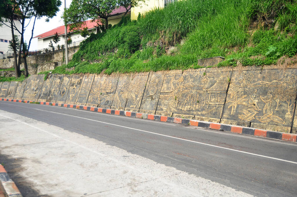 Τέχνη γλυπτική και σκάλισμα στον τοίχο ινδονησιακό στυλ με την κυκλοφορία του δρόμου για να δείξει στους επισκέπτες ταξιδιώτες ταξιδεύουν επίσκεψη δίπλα στο δρόμο στο Berastagi της Karna σε Sumatera Utara ή Βόρεια Σουμάτρα, Ινδονησία - Φωτογραφία, εικόνα