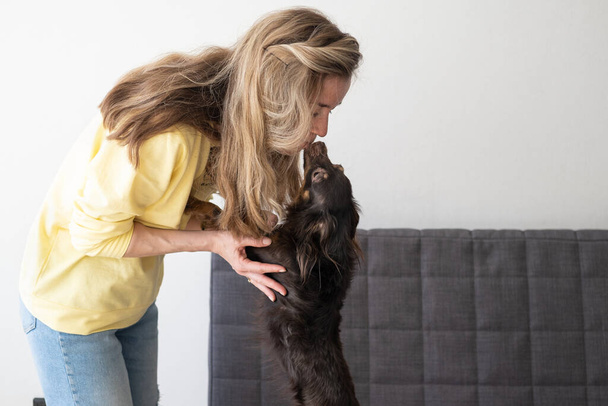 joven rubia mujer beso divertido marrón ruso juguete terrier  - Foto, Imagen