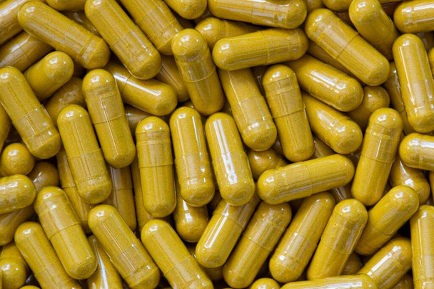 Turmeric Curcumin supplement capsules scattered loosely, close up macro flat lay image. Sold as an herbal anti-inflammatory remedy. - Photo, Image
