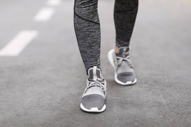 Sapatos para treinamento. Pernas Femininas em Sportswear e sapatilhas andando no caminho - Foto, Imagem