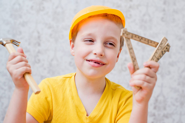 Il giovane costruttore. bambino con casco da costruzione piccolo martello e metro in legno - Foto, immagini