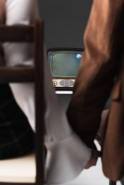 recortado vista de borrosa pareja viendo vintage tv en gris fondo - Foto, Imagen