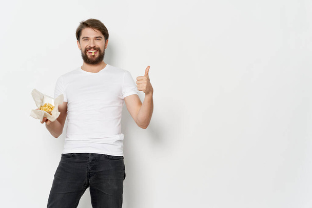 ein Mann mit einem Päckchen Pommes-Kalorien in der Hand - Foto, Bild