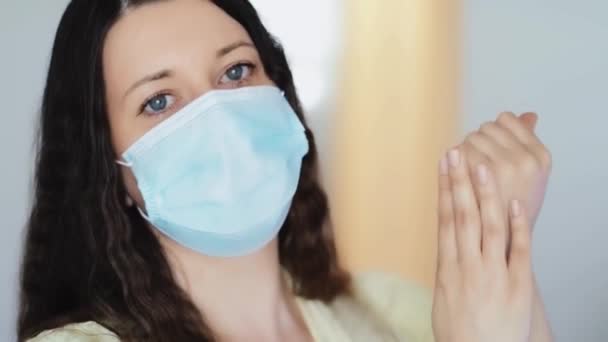 Жінка в захисній масці для обличчя миє руки з дезінфікуючим милом, крем для рук або антивірусний, антибактеріальний гель як гігієна при пандемії коронавірусу, профілактиці вірусної інфекції та захисті здоров'я
 - Кадри, відео