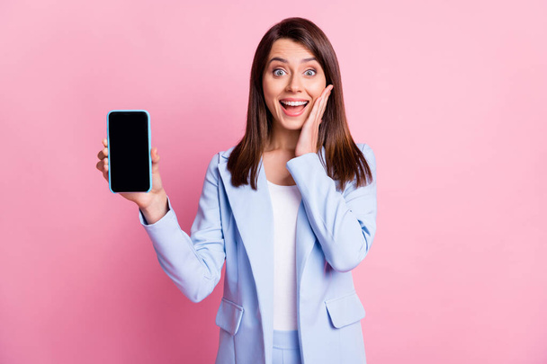 Photo of young girl excited amazed surprised happy smile hold cellphone hand touch cheeks isolated over pink color background - Φωτογραφία, εικόνα
