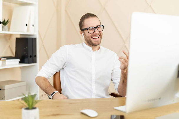 Smiling male office employee has pleasant video meeting - Foto, Imagen