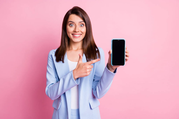 Photo of young excited happy smile girl point index finger smartphone ad promo advice isolated over pastel color background - Foto, Imagem