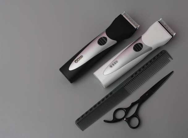 Professional Hairdressing Tools on a Gray Striped Background. Scissors and Hair Clippers, Shaver  and Comb Stylized in Classic Black and White Colors With Metal Blades - Photo, Image