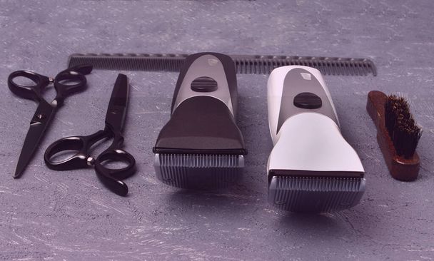Profesionální tvrdicí nástroje na šedém mramorovém pozadí. Nůžky a tenké nůžky, nůžky na vlasy, hřeben a kartáč stylizované v klasické černé a bílé barvě s kovovými noži - Fotografie, Obrázek
