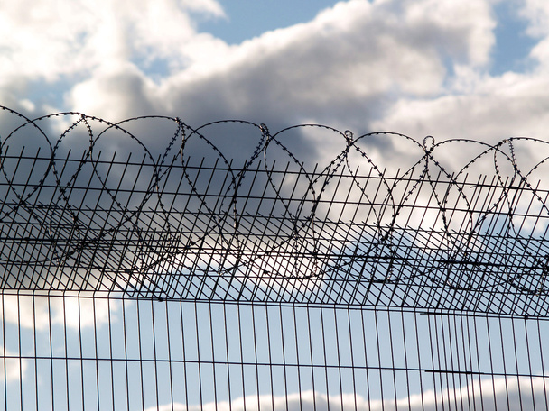 börtön kerítés szögesdróttal - Fotó, kép