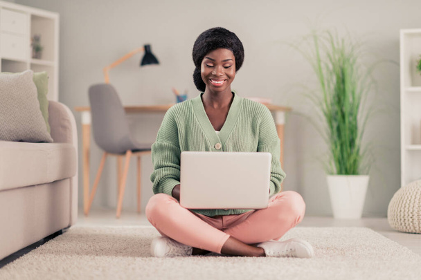 Full body photo of young african woman happy positive smile work laptop watch seminar type report sit floor indoors - Photo, Image
