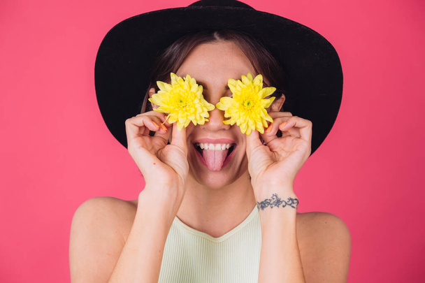 Mulher elegante em chapéu no fundo vermelho rosa mostra a língua cobrir os olhos com astros amarelos, humor primavera, emoções felizes espaço isolado engraçado - Foto, Imagem