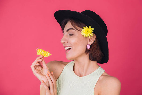 Mujer con estilo en sombrero sobre fondo rojo rosado sonriendo con dos astros amarillos, estado de ánimo de primavera, emociones felices espacio aislado - Foto, Imagen