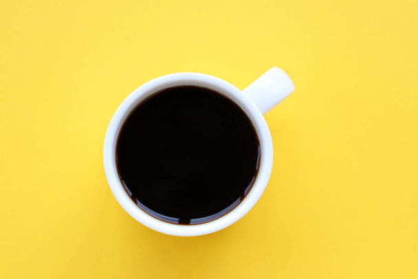 Cup of coffee on a yellow background. Top view, copy space - Photo, image