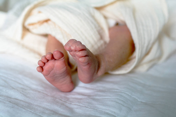 Leuke pasgeboren baby voeten met kleine tenen in een selectieve focus - Foto, afbeelding
