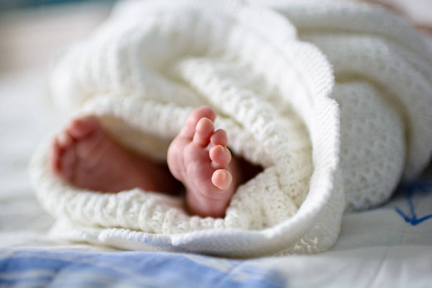 Cute newborn baby feet with little toes in a selective focus - Foto, Imagem