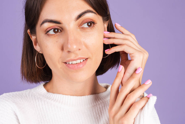 Beauty nagel concept, kleine vrouw met roze lente kleur manicure witte trui paarse achtergrond - Foto, afbeelding