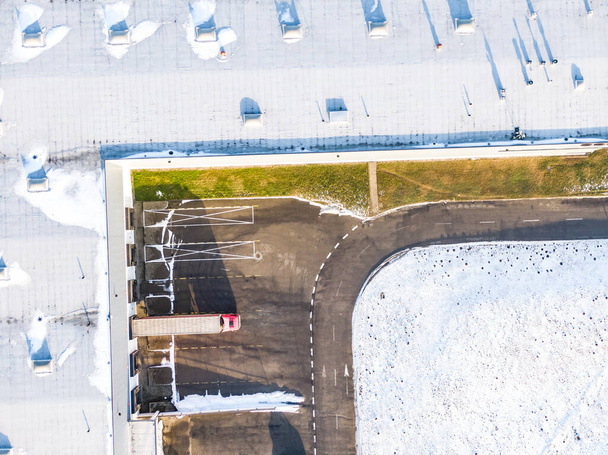 Вид с воздуха на разгрузку грузовиков в логистическом центре. Фотография дронов. - Фото, изображение