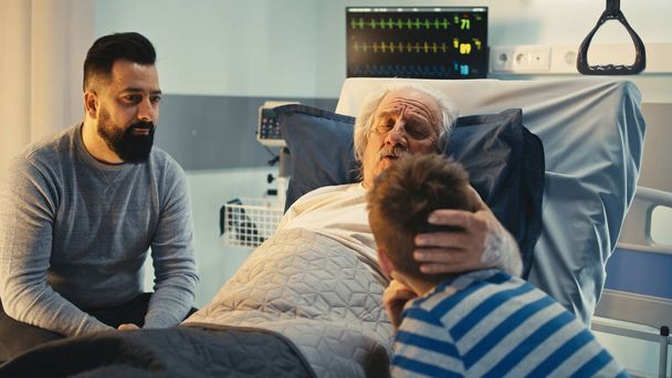 Starší muž mluví se synem a vnukem v nemocnici - Fotografie, Obrázek