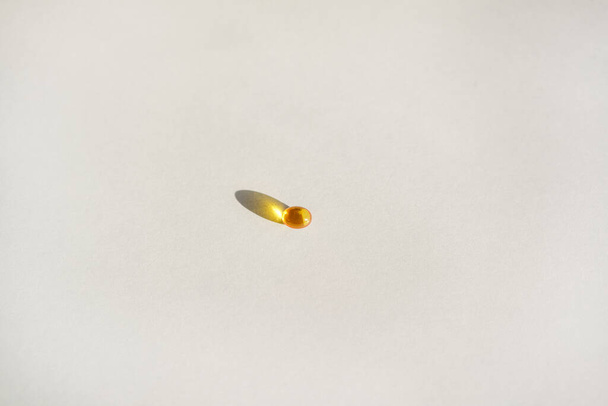 Gele gel transparante gel capsules van vitamine d of omega 3 in lepel. - Foto, afbeelding