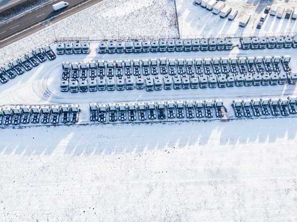 Aerial top view új teherautók parkoló eladó stock sor, kereskedő leltár import és export üzleti kereskedelmi, Autó- és autóipari forgalmazás logisztikai globális közlekedés - Fotó, kép