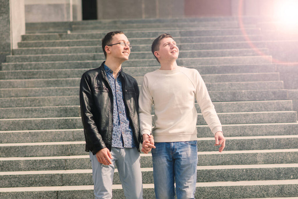 Mutlu bir şekilde gülümseyen ve şehirde sarılan genç eşcinsel çift.. - Fotoğraf, Görsel