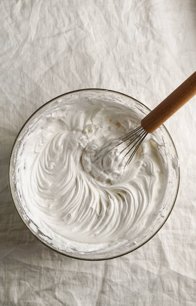 merengue crema, claras de huevo batidas, crema batida en un recipiente de cocina con un batidor - Foto, imagen