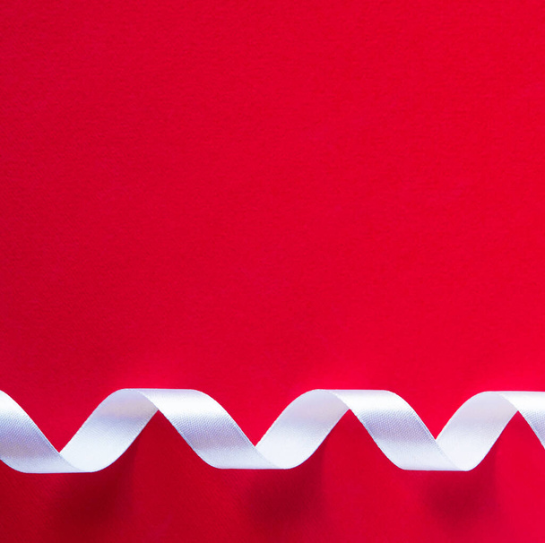 Red paper background with minimalist ribbon decor. Contrast and minimalism concept. - Valokuva, kuva