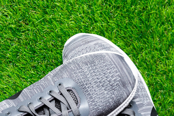 Gray sneakers on green grass. One sneaker lies on top of the other. Sports concept. - Valokuva, kuva