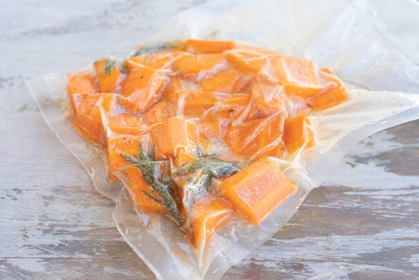 Vacuum sealed bag with carrots ready for low temperature cooking. - Photo, Image