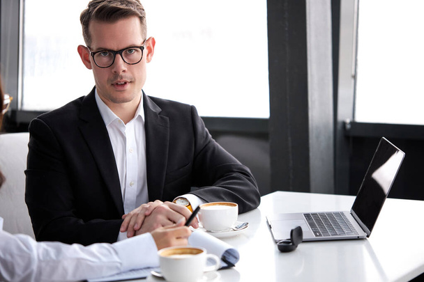 handsome caucasian businessman in spectacles sit having conversation with colleague - Photo, image